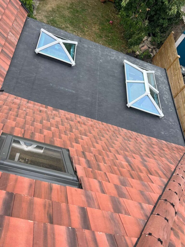 This is a photo taken from the roof ridge looking down a tiled pitched roof on to a flat roof. Works carried out by Ravenshead Roofing Repairs